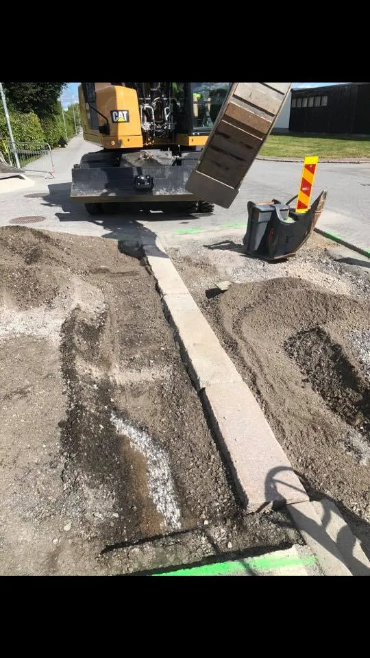 Grävmaskin med tillbehör vid kantstensarbete