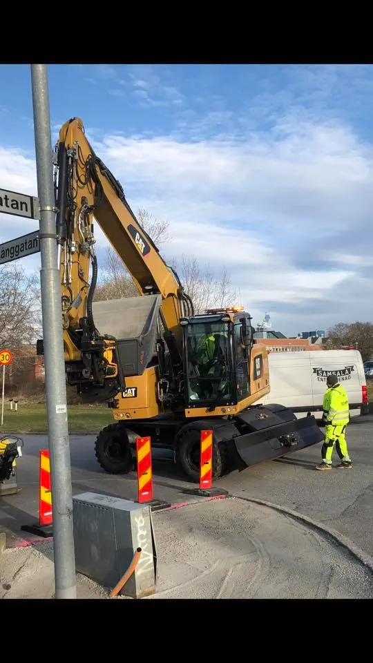 Grävmaskin vid gatukorsning med Samsala-van