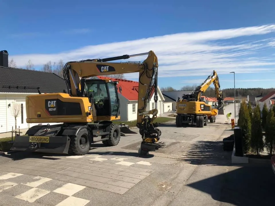 Två CAT-maskiner i villaområde